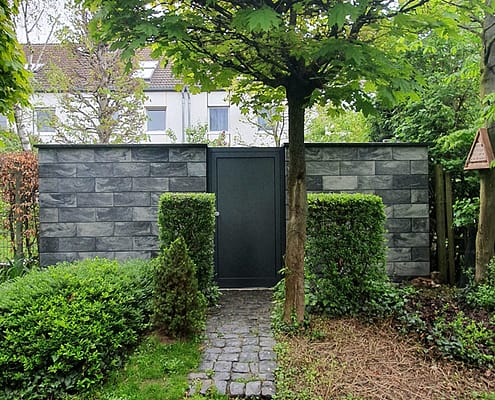 Einzigartiges Eingangsportal - Haustür in Gartenmauer
